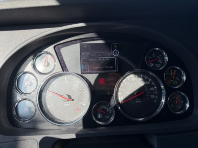 Kenworth T680 dash panel with multiple gauges and digital display showing neutral, engine status, and message; circular speedometer and tachometer with other smaller gauges.