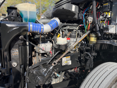 Kenworth T680 engine bay showing various hoses, wiring and components in-service.