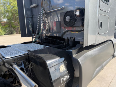 Kenworth T680 truck engine bay area with TriPac auxiliary cooling unit and rear of cab visible.