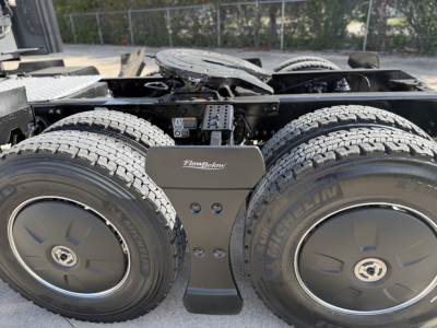 Kenworth T680 tractor rear twin-axle wheels with Flowbelow fuel/brake fairing and Michelin tires, chassis frame visible, ID plate area in view.