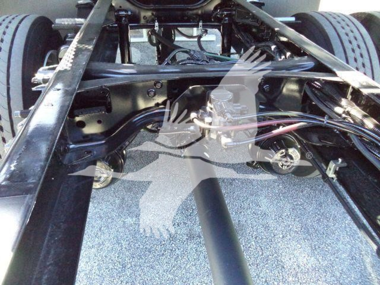 Ford F750 chassis frame view showing suspension components and fuel lines in a rollback truck configuration.
