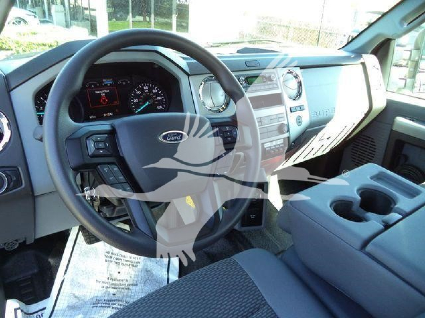 Ford F-750 cab interior showing steering wheel dashboard center console and cup holders.