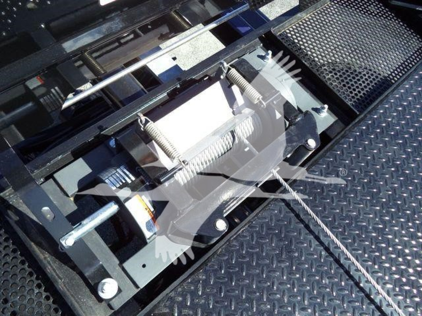 Ford F750Rollback truck component view showing hydraulic winch mechanism and steel grating platform