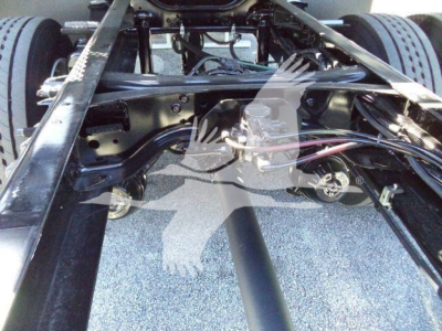Ford F750 chassis frame view showing suspension components and fuel lines in a rollback truck configuration.