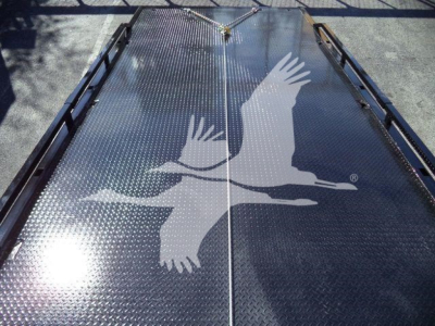 Flatbed tow truck deck with diamond plate surface and a large white hawk graphic in the center.