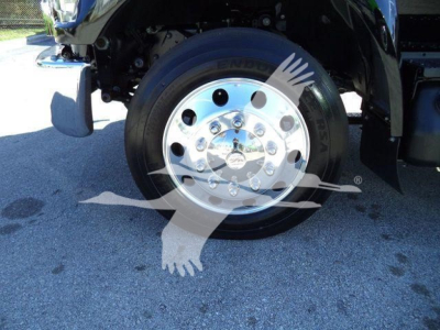 Front wheel assembly of a 2024 Ford F750 rollback truck showing a polished chrome wheel with lug nuts and tire, part of the front right side.