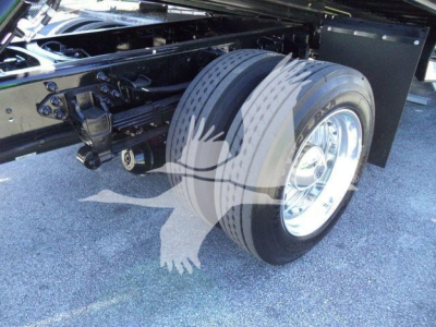 Truck rear wheel and chassis of a 2024 Ford F750 rollback showing dual rear tires and frame components.
