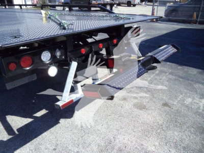 Ford F-750 rollback truck rear showing flatbed with foldable ramps and taillights.