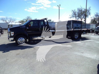 Ford F750 rollback truck in view showing cab and flatbed with stock text overlays obscuring center of image.