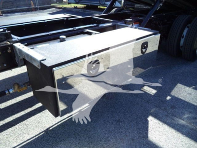 Truck bed toolbox mounted on Ford F-750 rollback chassis showing a metal rectangular toolbox with lockable latch and mounting studs.