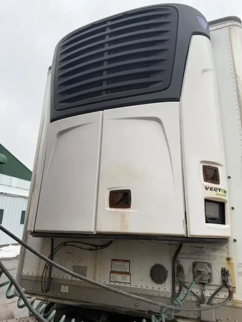 Front view of a refrigerated trailer refrigeration unit with black grille and white bulkhead, VECTON label and access panels visible.