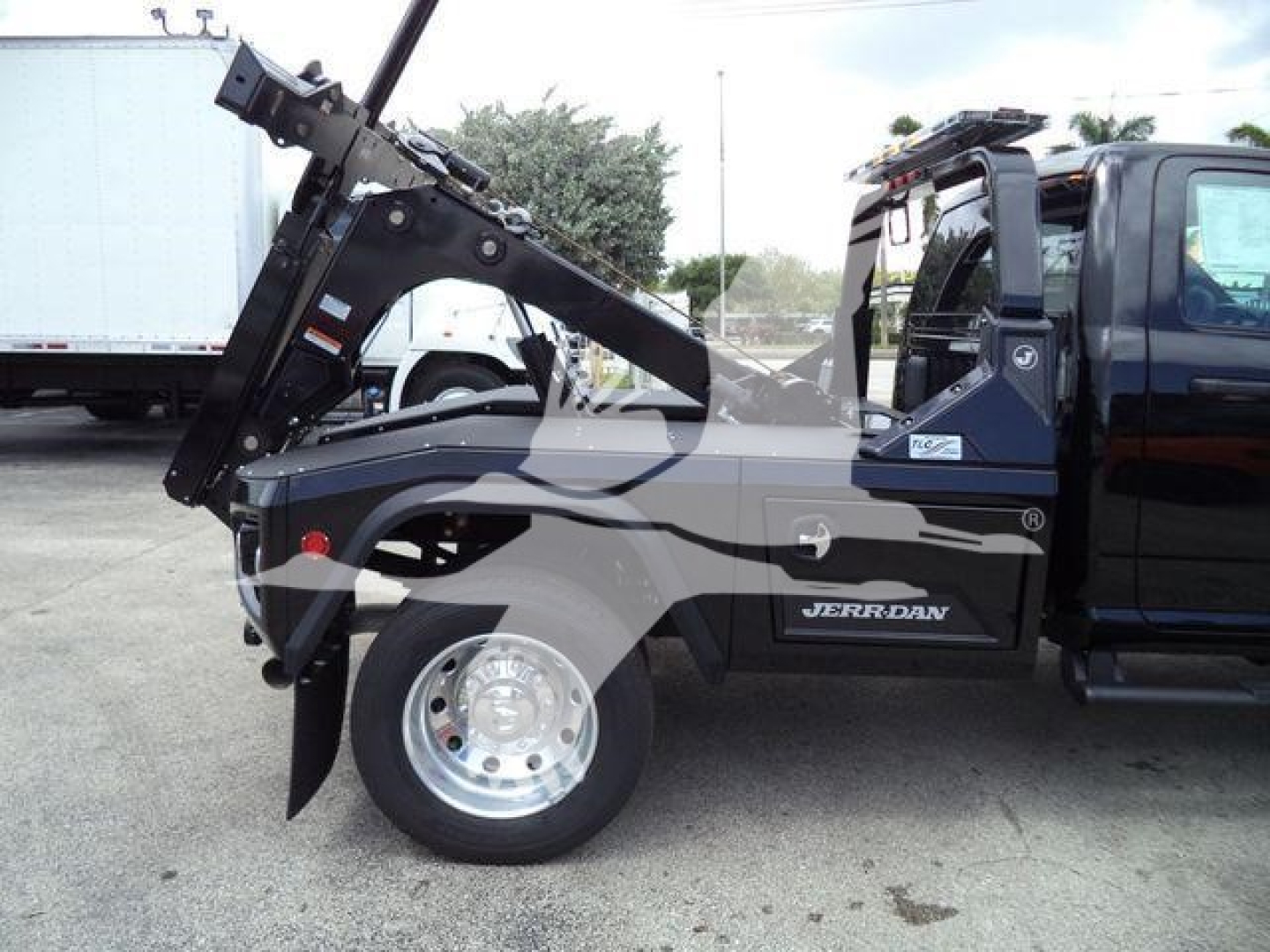 Ram 4500 tow truck side view showing hydraulic winch arm and black body with Jerr-Dan branding.