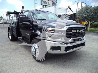 Ram 4500 big horn pickup truck in showroom lot with chrome grille and badge, front-left view, lifted front wheel off the ground.