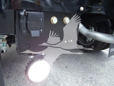 Ram 4500 winch package area showing electrical connector box and mounts with large hitch bolt and rounded fog light in front bumper panel.