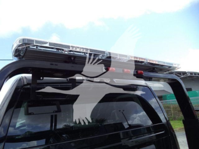 Ram 4500 winch truck rear with roof-mounted light bar and rear window. Text not legible.
