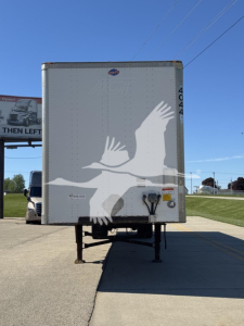 Trailer back showing graphic of two birds in flight on a white surface with landing gear visible.