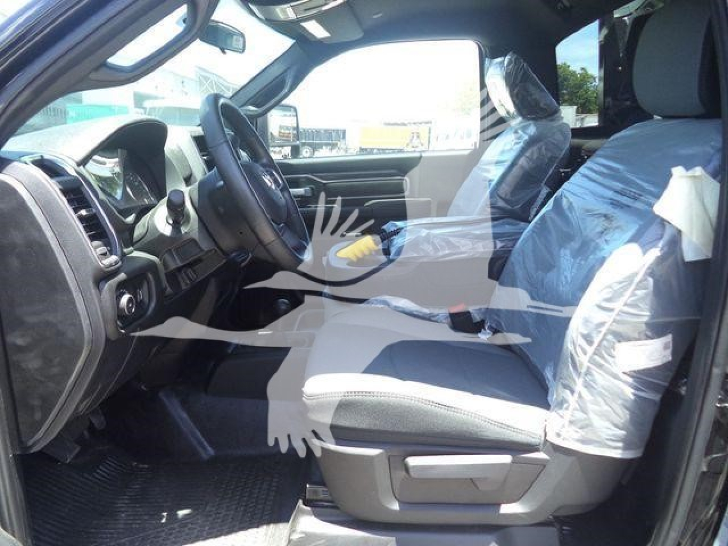 Ram 4500 SLT interior view showing driver and passenger seats wrapped in plastic, front cabin with steering wheel and dashboard visible.