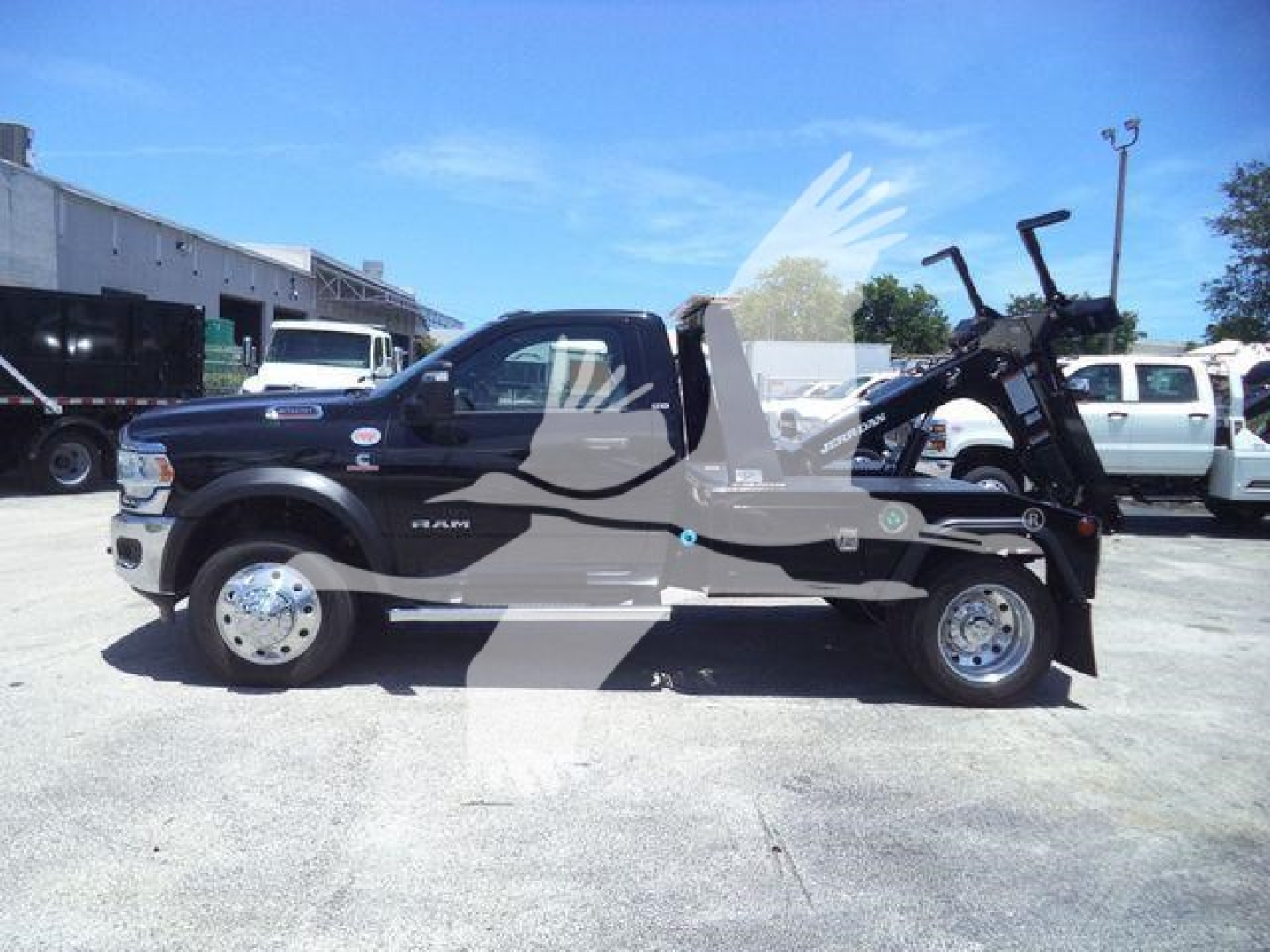 Ram 4500 SLT pickup with winch, side view, showing truck cab, long wheelbase, and a motorcycle loaded in bed; no visible text legible besides vehicle features.