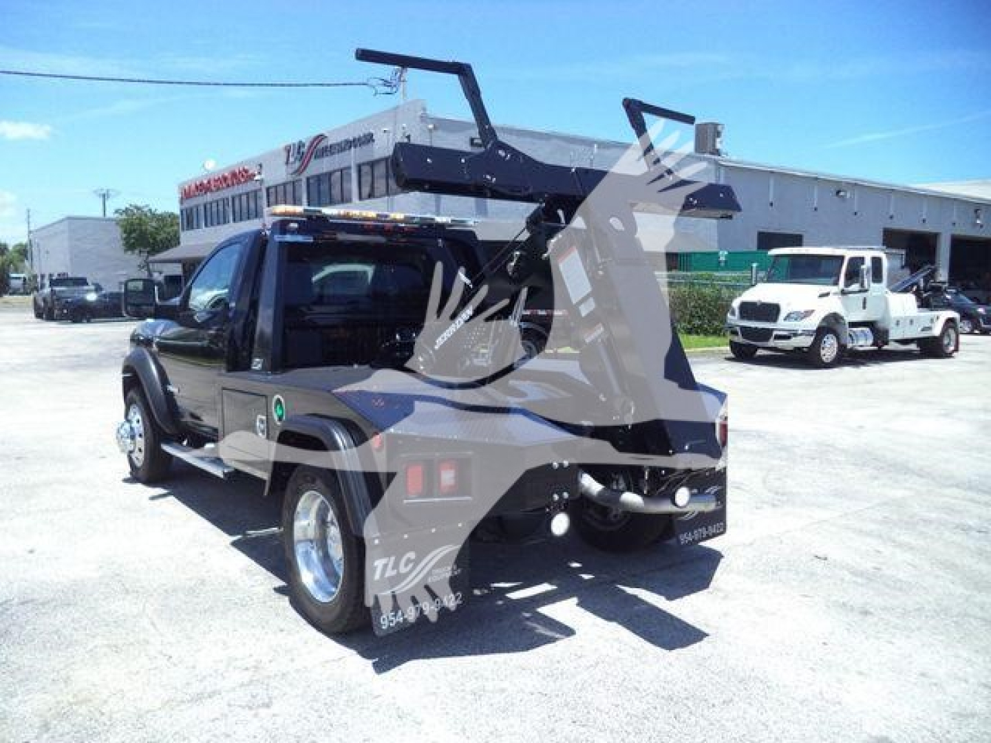 2024 Ram 4500 SLT pickup with an aftermarket winch and tow setup mounted behind cab; exhaust and dual rear wheels visible; dealership lot in background.