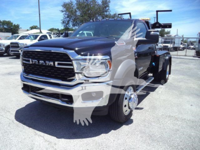 Ram 4500 SLT front three-quarter view showing chrome grille, RAM lettering, black upper body, dual rear wheels, winch equipment carrier in a dealership lot.
