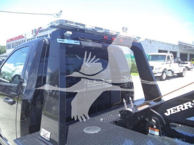 Ram 4500 SLT truck rear with winch equipment and manufacturer stickers visible on bed, side view mirror and rear window.