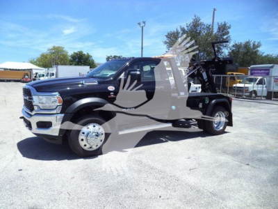 Ram 4500 tow truck in a dealership lot, front-left view, with winch and equipment on bed