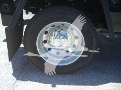 Truck wheel and tire from a 2024 Ram 4500 SLT showing a chrome hubcap and tire branding on the sidewall.