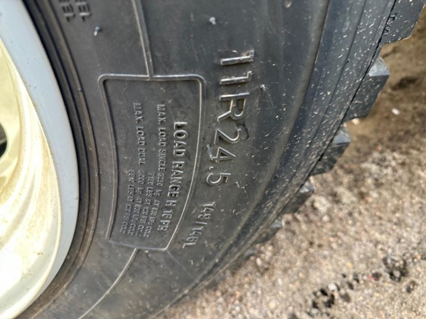 Tire sidewall with molded markings showing 'TIRES' and load label; visible text includes 'LOAD BALANCE 4 5' and other small print on the tire tag near the wheel.