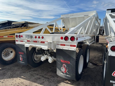 Dump trailer rear view showing tandem axles with white Ranco Versa brand mud flaps and triangle bed frame.