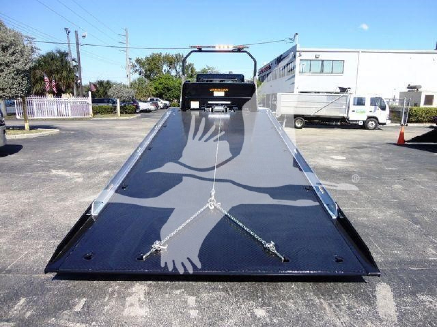2022 Peterbilt 337 rollback truck bed in front view, metal flatbed with chrome anchors and chain tie-downs.