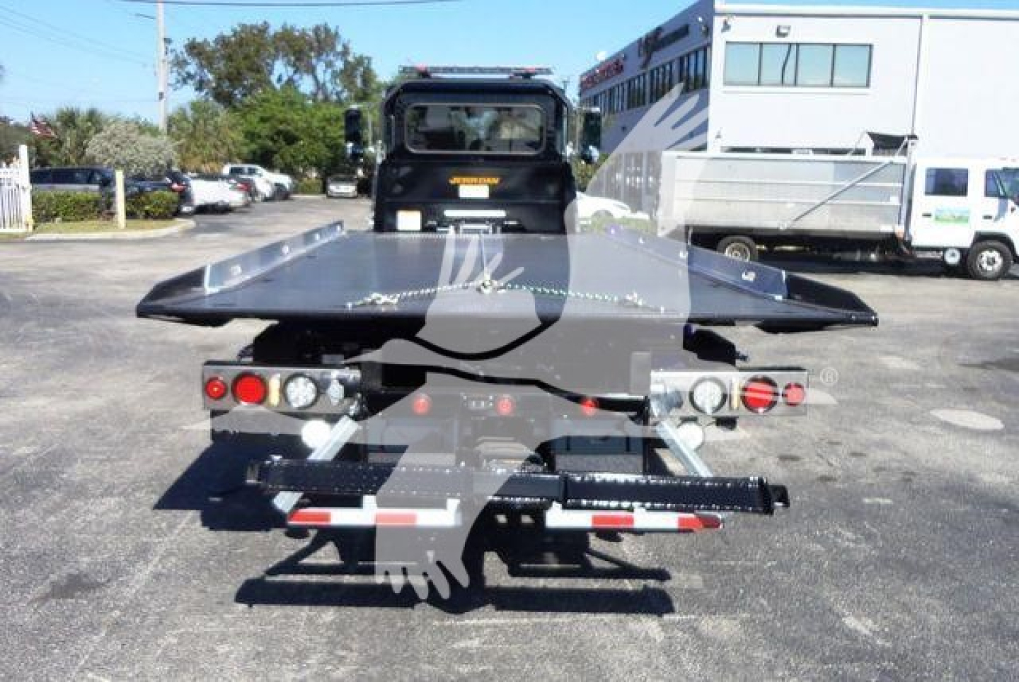 Truck rear view showing rollback bed and tow equipment on a 2022 Peterbilt 337 with a flatbed/platform.