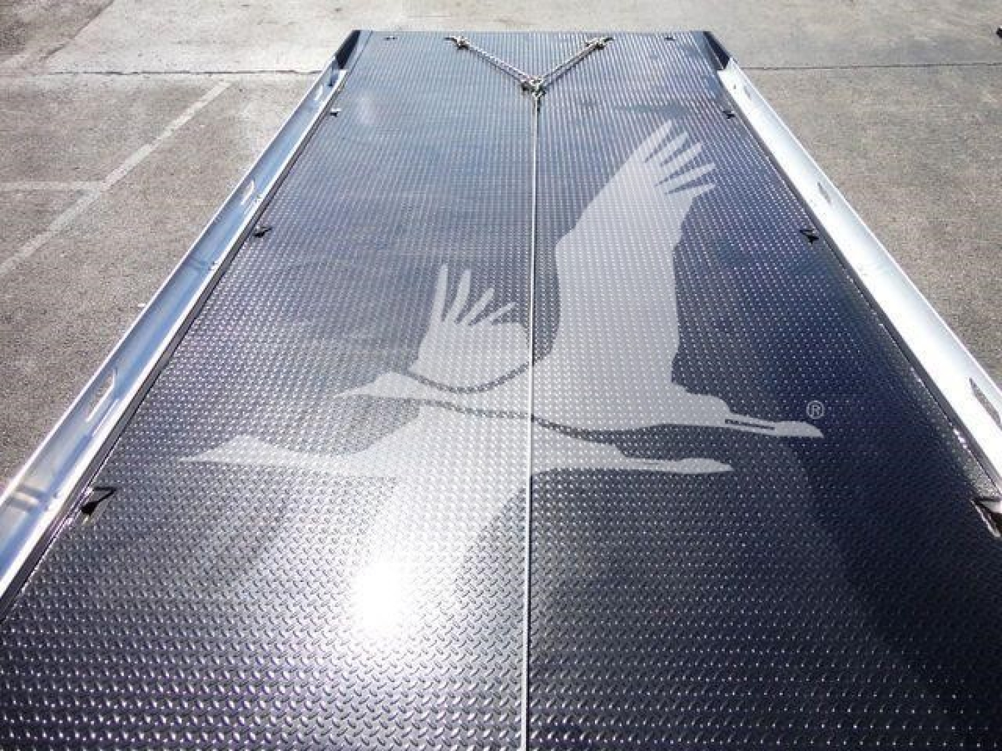 Peterbilt 337 rollback bed image showing diamond tread metal surface with eagle logo centered.