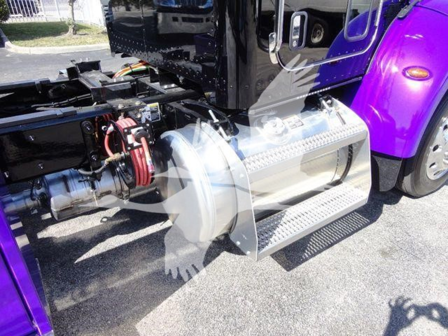 Peterbilt 337 rollback truck with exposed fuel tank and steps; close-up of chassis area, purple cab, metallic fuel tank and ladder step.