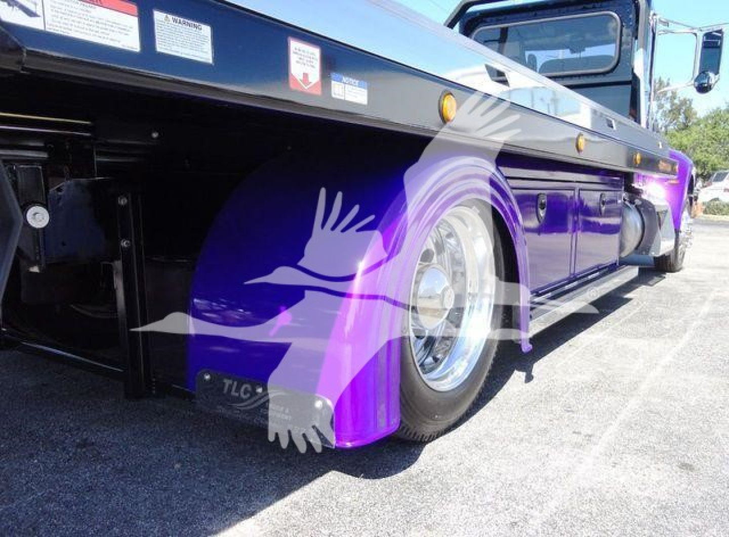 Peterbilt 337 rollback truck side view showing purple fender and chrome wheel with low-angle perspective