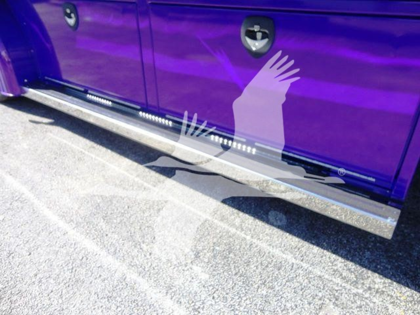 Side view of a purple Peterbilt 337 rollback truck showing side steps and lower chrome running boards.
