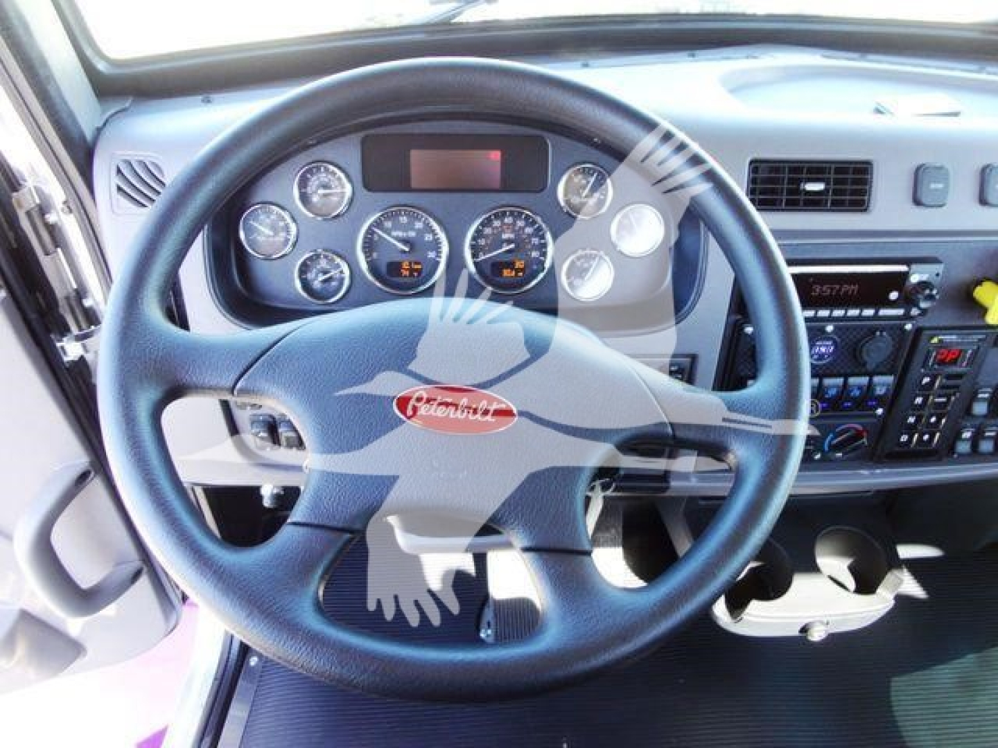 Peterbilt truck interior showing steering wheel with Peterbilt emblem and instrument cluster.