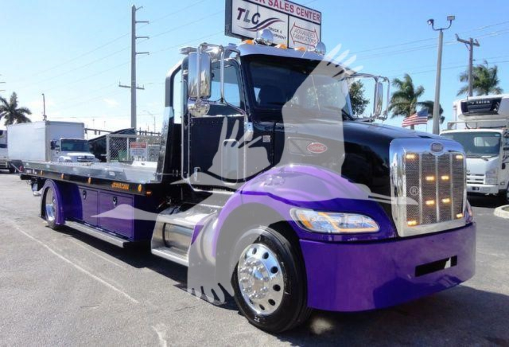Peterbilt 337 rollback truck in black and purple livery, front grille, chrome bumper, and long flatbed viewed from driver side.