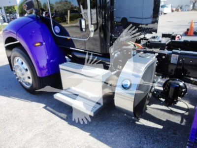 Truck side view showing steps and chassis of a 2022 Peterbilt 337 rollback truck with purple fender and chrome steps.