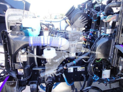 Peterbilt 337 engine bay showing various hoses, wiring, and fluid reservoirs with blue and white components.