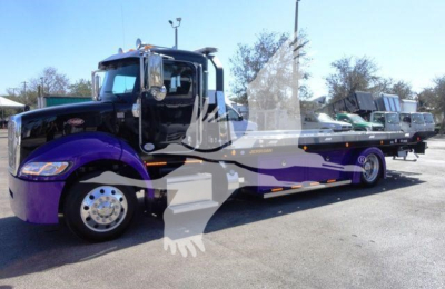 Peterbilt 337 rollback truck in service position with purple and gray graphics, long wheelbase, showing cab and wrecker bed.