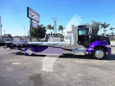 Peterbilt 337 rollback truck with purple accents parked outdoors, side view showing flatbed/wrecker setup.