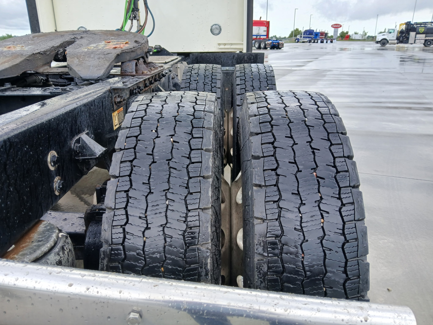 Kenworth W900L chassis and dual rear axles with dual tires in view, visible wear on tread and wheel rims.
