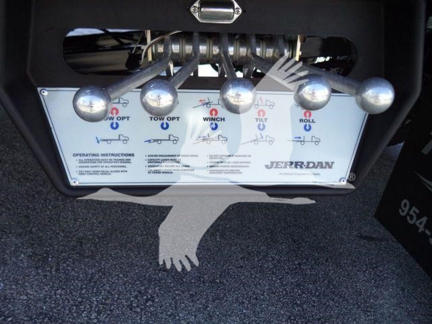 Truck control panel with multiple levers and labels showing tow/boom functions on a rollback tow bed.