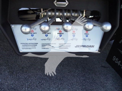 Truck control panel with multiple levers and labels showing tow/boom functions on a rollback tow bed.
