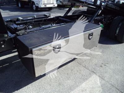 Truck bed toolbox mounted under a rollback chassis with two large lockable compartments and a flat top surface.