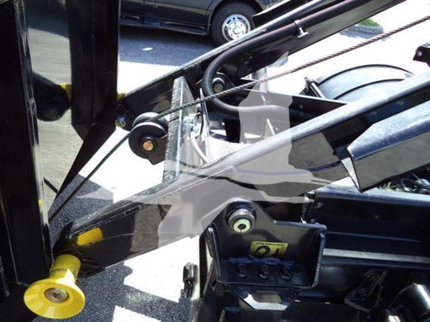 Ford F-550 rolloff truck engine bay showing hydraulic lines and chassis components.