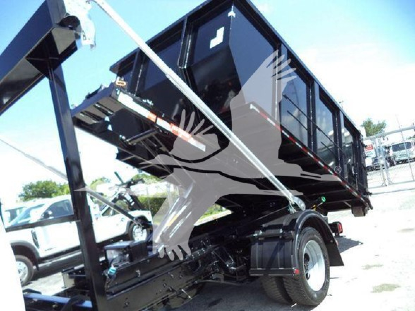 Ford F-550 dump truck side view with hydraulics and tipping bed visible; no legible text on components.