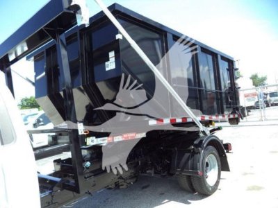 Ford F-550 rolloff truck rear tire and cargo body with hydraulic system and dump bed visible.