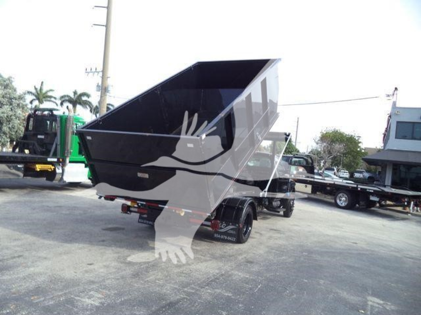 Dump bed trailer showing raised bed on dual-axle Silverado 6500HD truck in an outdoor lot.