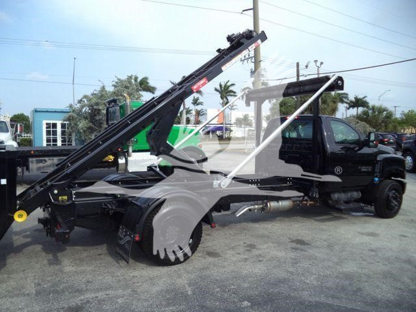 Truck chassis and hoist system showing a 2023 Chevrolet Silverado 6500HD rolloff with tow hoist and crane in black, side view.
